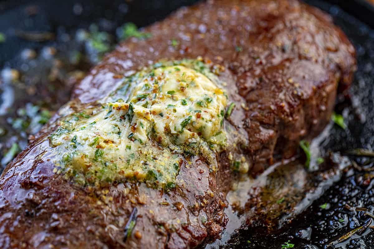 Cowboy Butter Melted on a Steak in a Skillet.