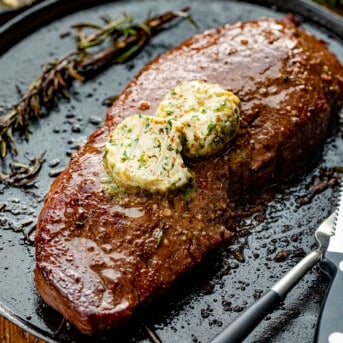 Grilled Steak with Cowboy Butter on It on a Skillet.
