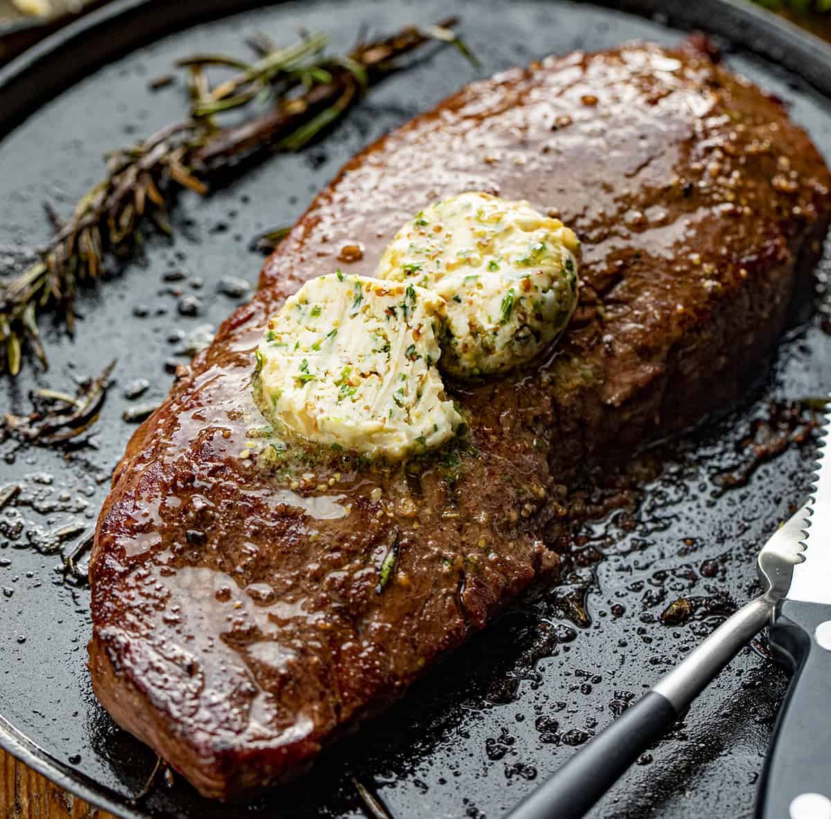 Grilled Steak with Cowboy Butter on It on a Skillet. 