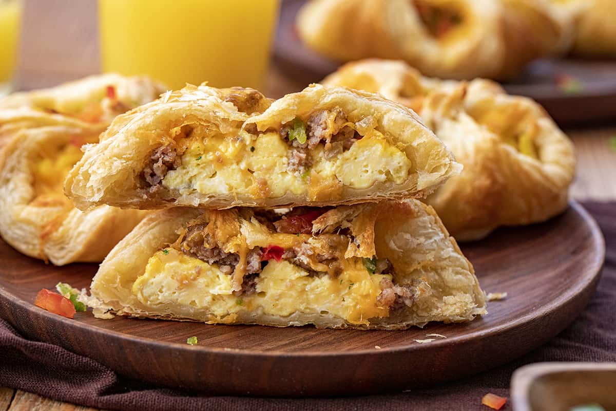 A Cowboy inspired Breakfast Puff Pastry Cut in Half on a Plate Showing Eggs, cheese, and Sausage Mixture Inside.