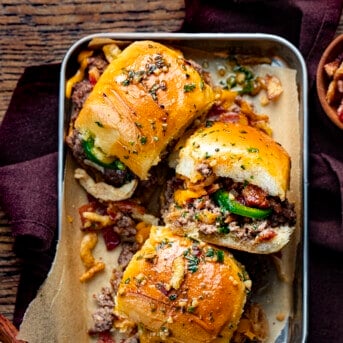 Platter with Cowboy Sliders in It Showing the Top and Sides and INgredients Spilling out on a Cutting Board.