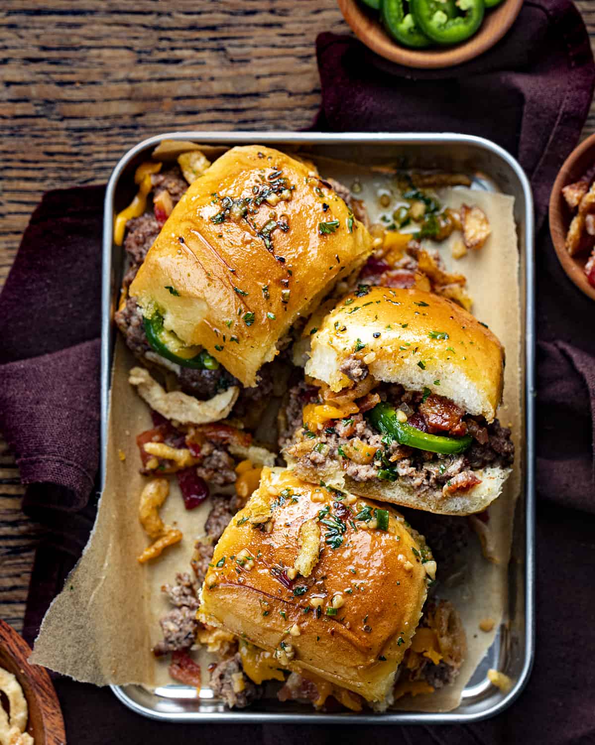 Platter with Cowboy Sliders in It Showing the Top and Sides and INgredients Spilling out on a Cutting Board.