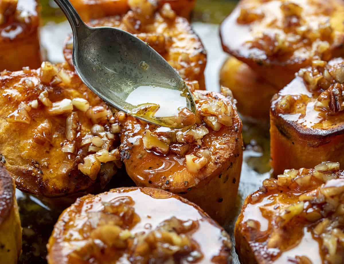 Spooning Bourbon Pecan Glaze over Fondant Sweet Potatoes.