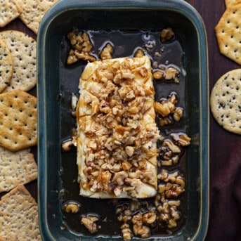 Spiced Cream Cheese in a mini casserole Dish Covered in Pecans and Surrounded by Crackers.