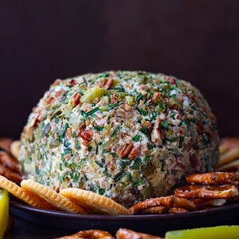 Whole Dill Pickle Cheese Ball on a Serving Platter with Crackers and Pretzels.