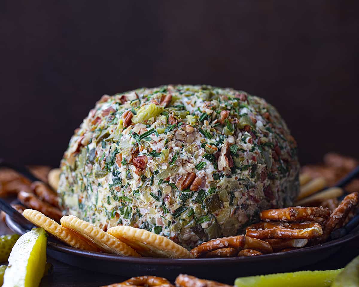 Whole Dill Pickle Cheese Ball on a Serving Platter with Crackers and Pretzels. 