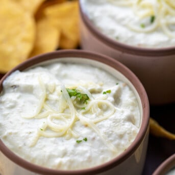 Mini Bowls of Easy Queso with Shredded Cheese and Surrounded by Chips.