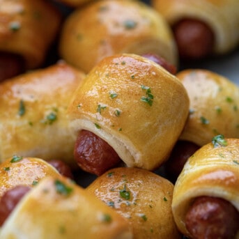 Pigs in a blanket appetizer stacked in a dish.