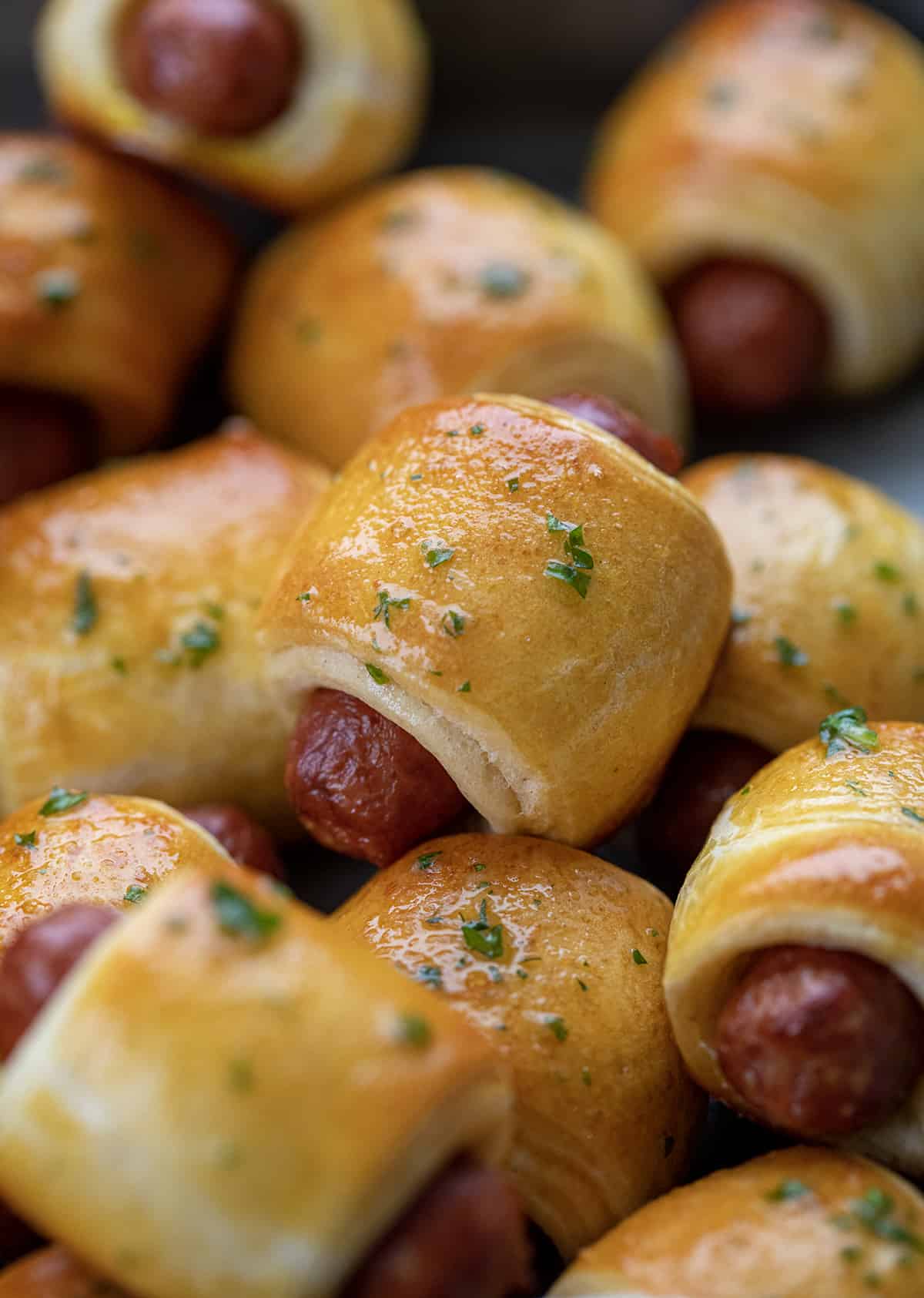 Pigs in a blanket appetizer stacked in a dish.