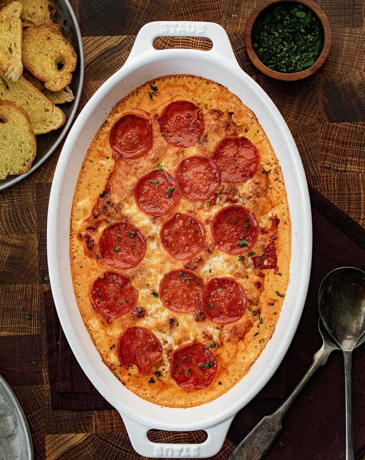 Skillet Pepperoni Pizza Dip fresh from the oven on a butcher block. 