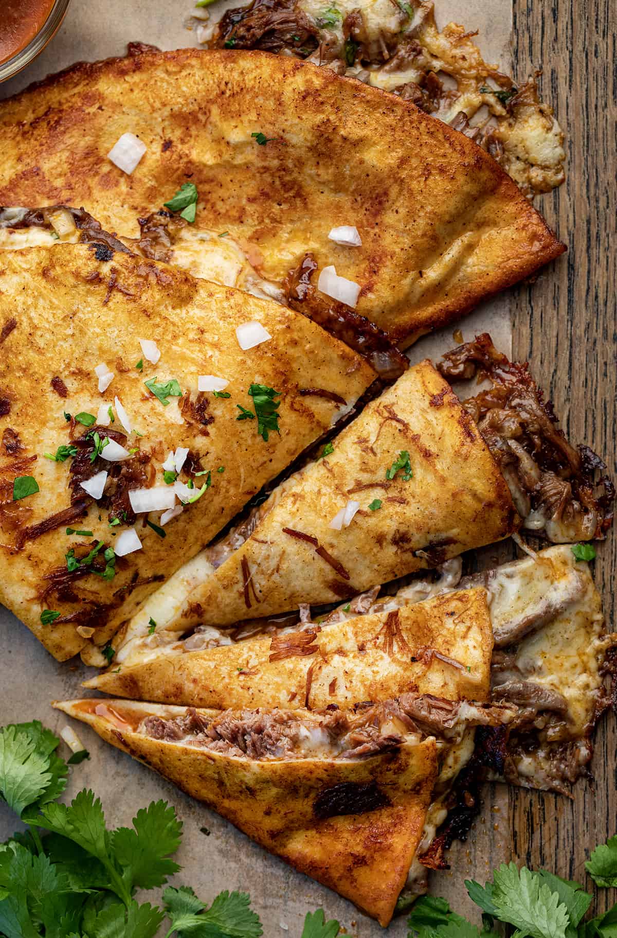 Birria Quesadillas ona. Cutting Board Cut Up Into Pieces.