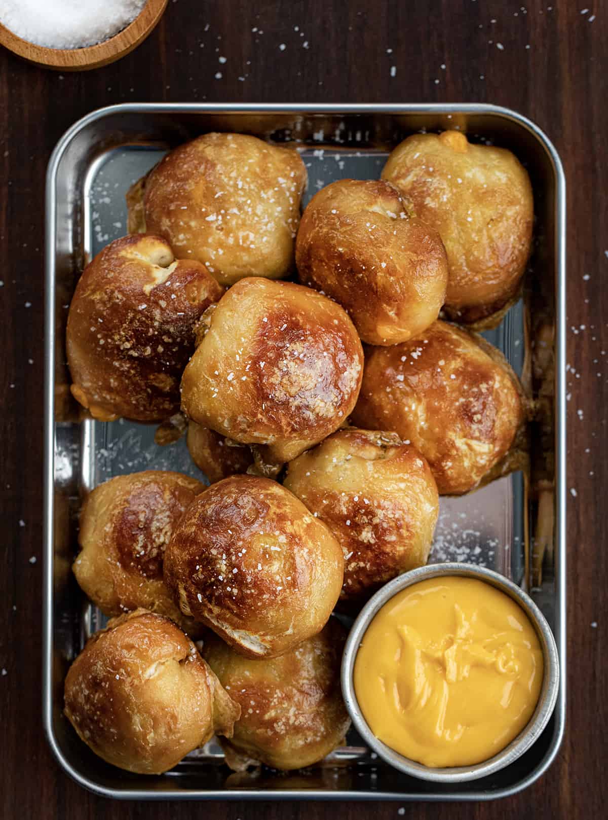 Pan of Cheese Stuffed Pretzel Bombs from Overhead with Side of Cheese.