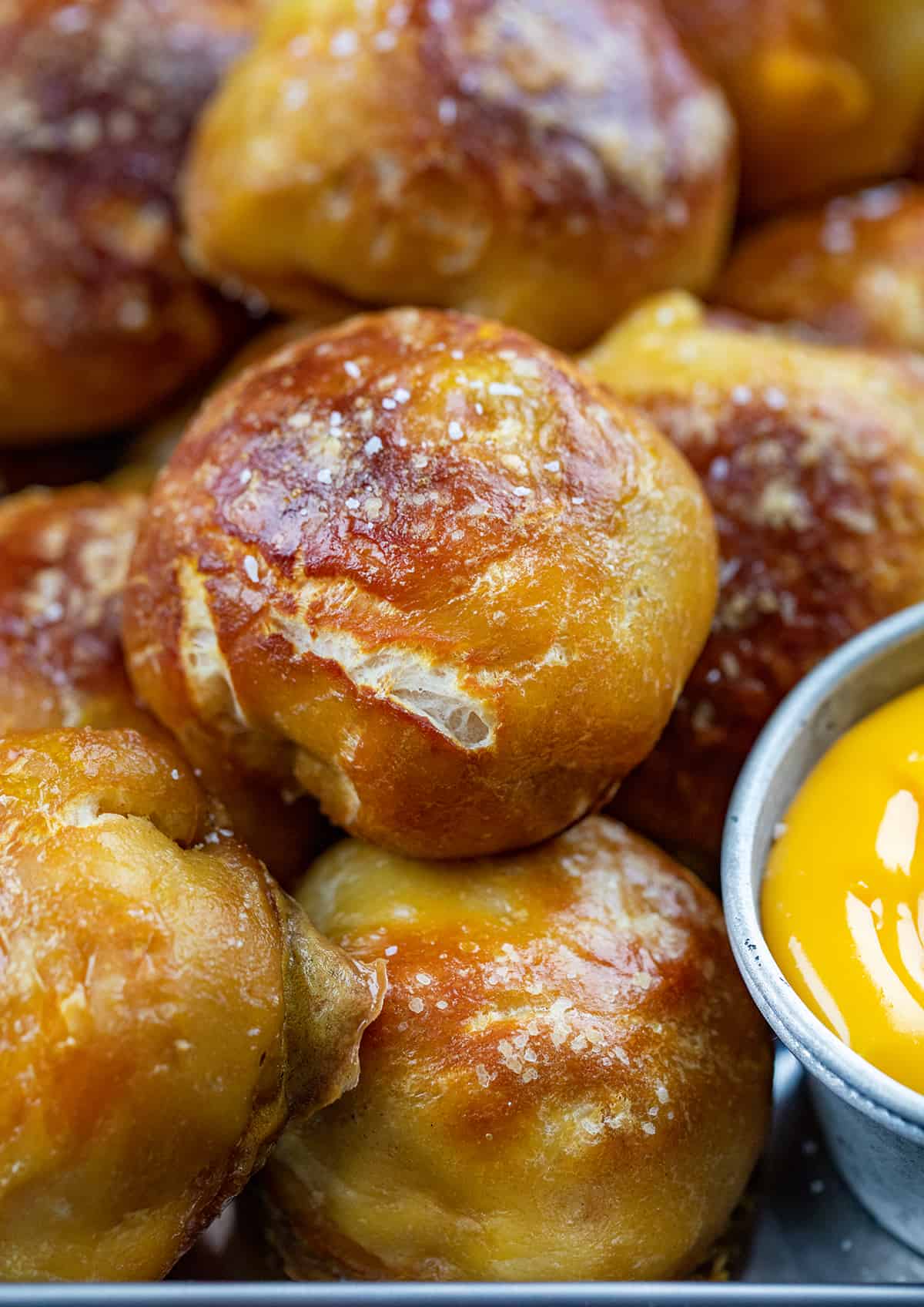 Close up of Cheese Stuffed Pretzel Bombs Next to Cheese Dip.
