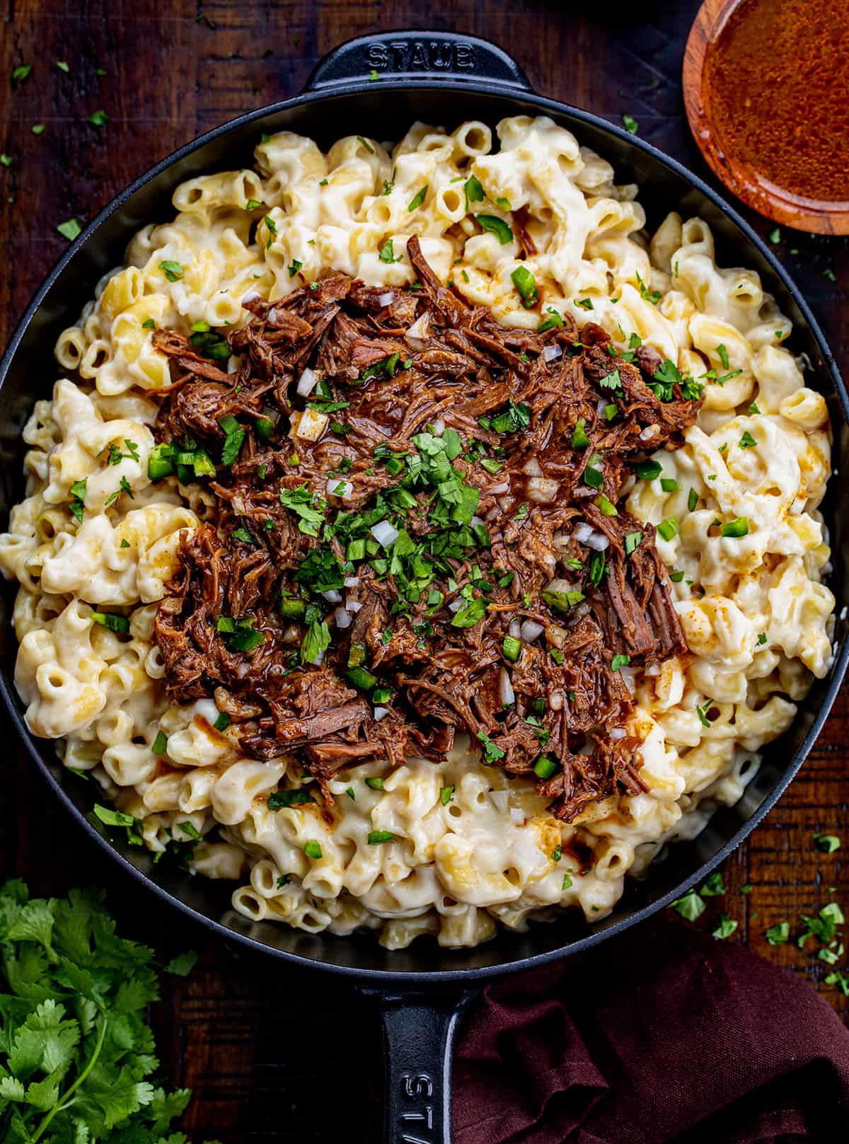 Skillet of Shredded Beef Macaroni and Cheese on a Cutting Board.