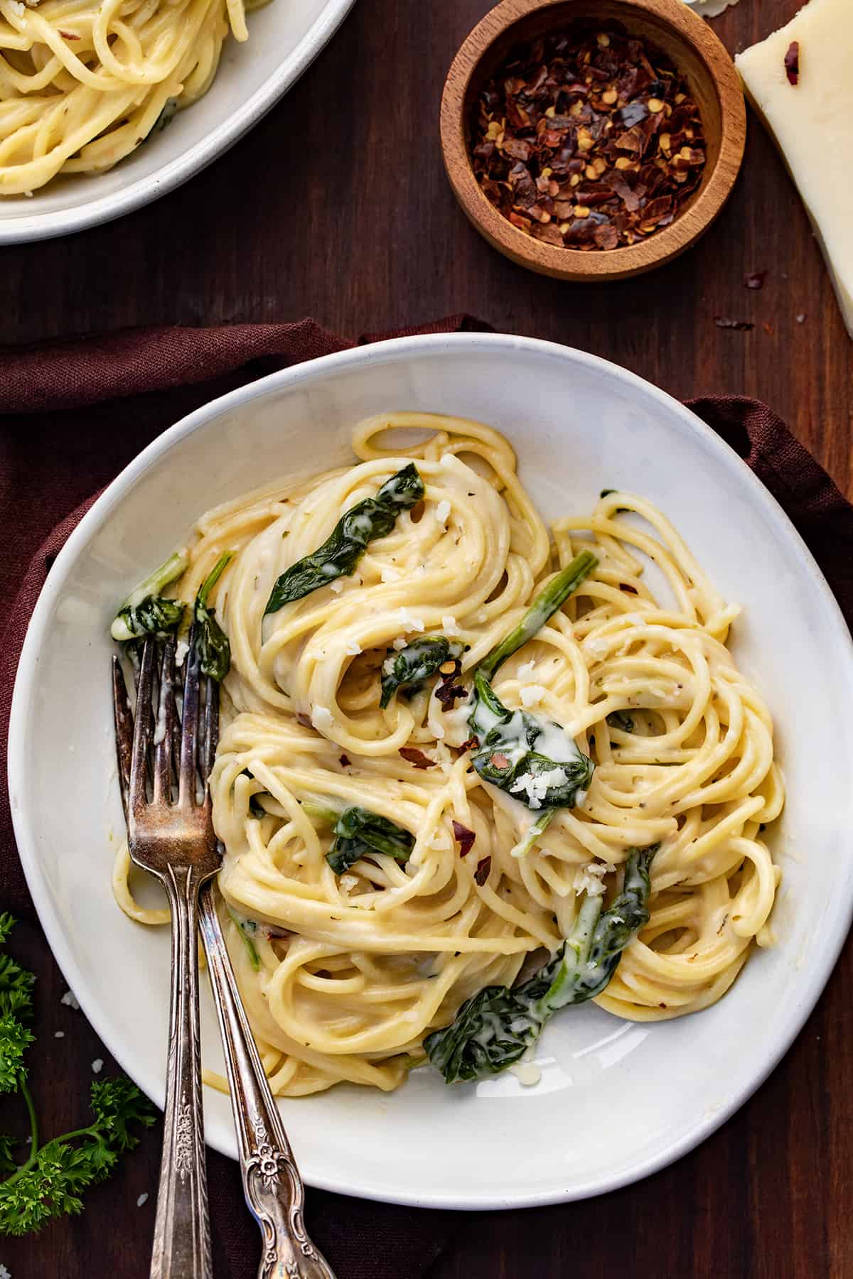 Plates of Asiago Pasta with Forks on a Cutting Board.