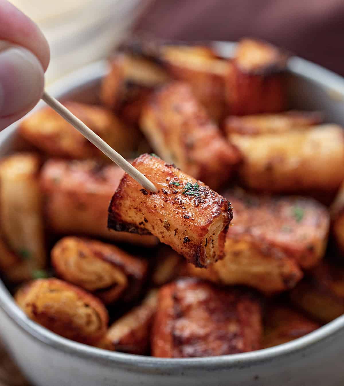 Hand Holding one Air Fryer Imitation Crab Bite on a Toothpick.