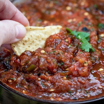 Hand Dipping Chip into Roasted Salsa.