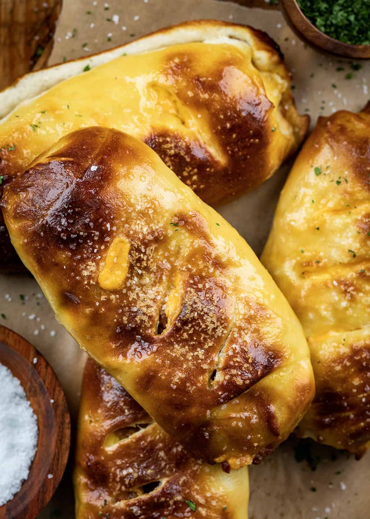 Stuffed Breakfast Pretzel Rolls on a Counter from Overhead Next to a Bowl of Salt.