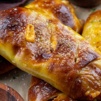 Stuffed Breakfast Pretzel Rolls on a Counter Stacked on Each other.