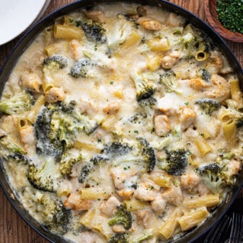 Chicken and Broccoli Pasta in a Skillet on a Wooden Cutting Board.