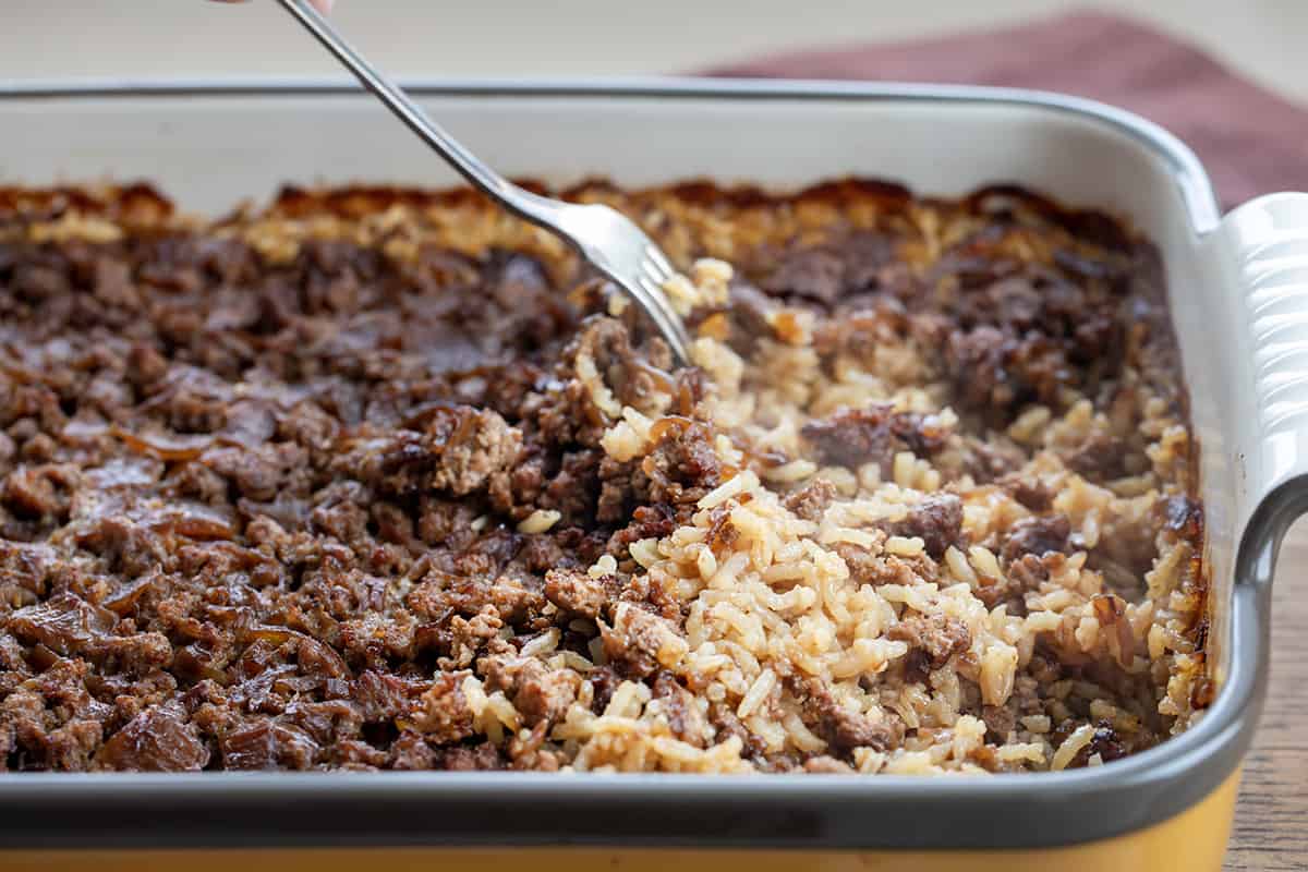 Fluffing Up Easy Hamburger Rice Casserole with a Fork After Baking.