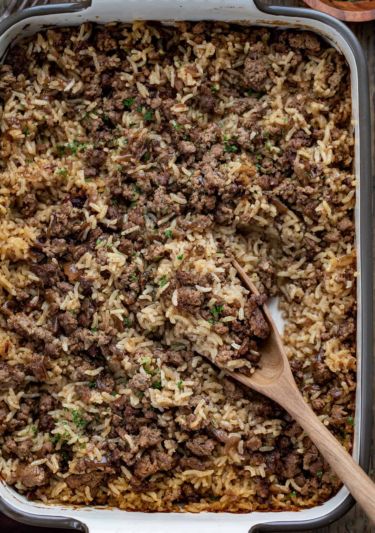 Fluffed up Easy Hamburger Rice Casserole From Overhead with a Wooden Spoon.