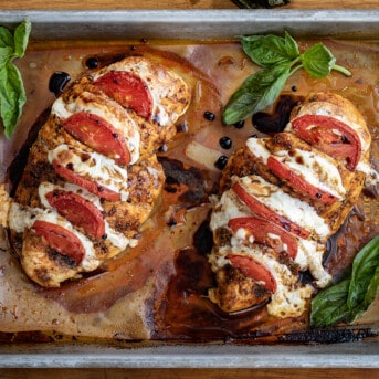 Caprese Hasselback Chicken that has finished baking and is garnished with fresh basil.