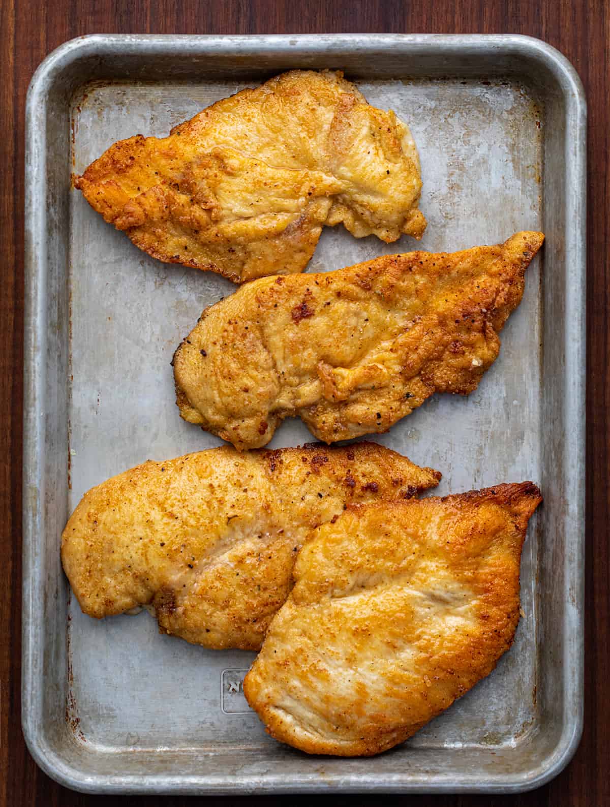 Cooked Chicken on a Pan Before Assembling Smothered Chicken.