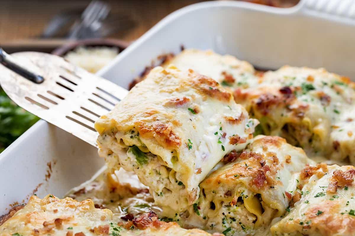 Spatula Picking Up a Chicken and Broccoli Alfredo Roll-Up From The Pan Right After Baking.