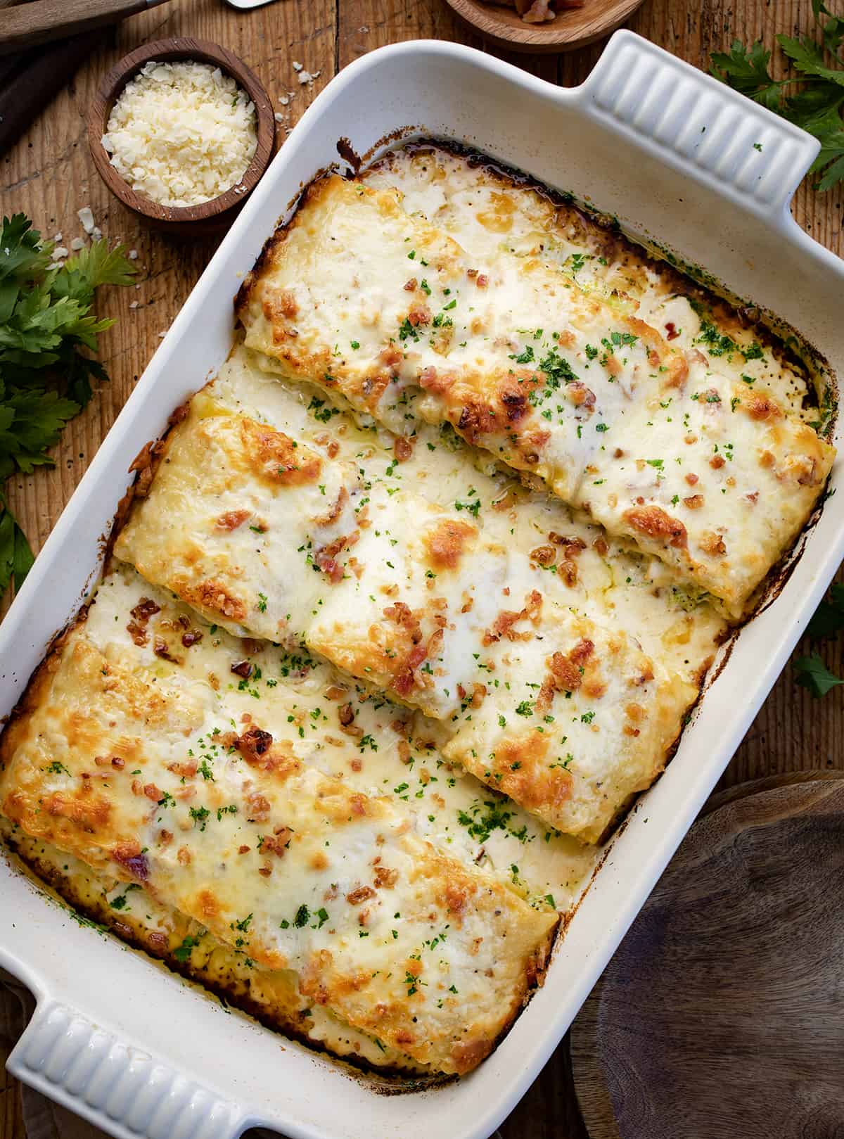 Overhead of Chicken and Broccoli Alfredo Roll-Ups in a Baking Dish on a Cutting Board. 