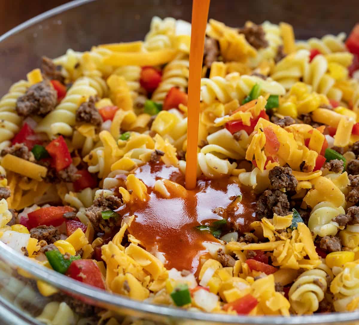 Pouring Dressing Over Taco Pasta Salad.