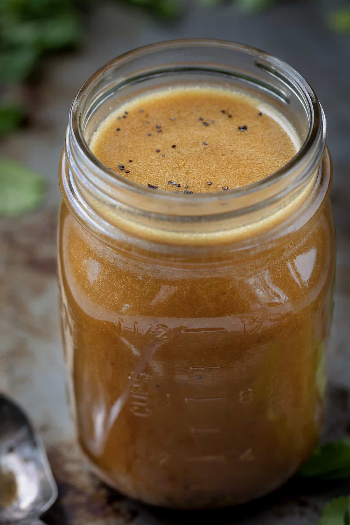 Jar of Creamy Balsamic Vinaigrette on a Counter with Greens.