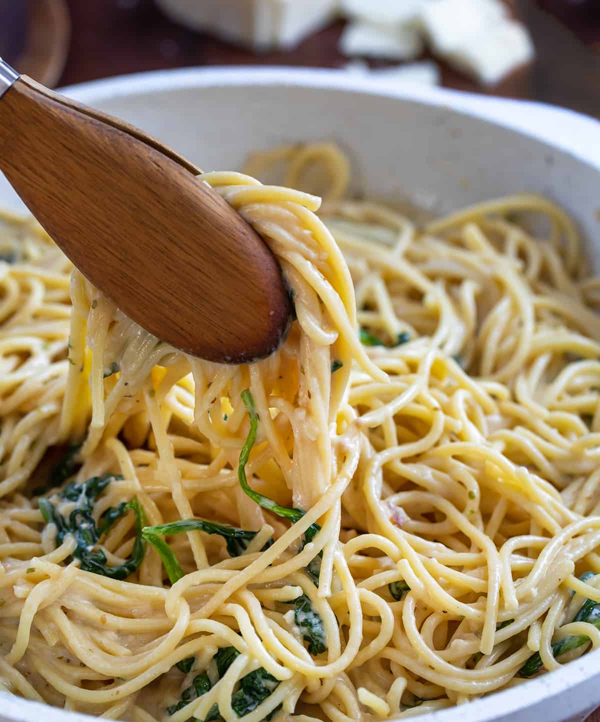 Tongs Picking up Creamy Asiago Pasta from Pan.