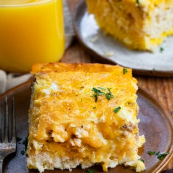 Pieces of Butter Biscuit Breakfast Bake on Plates and a Glass of Orange Juice.