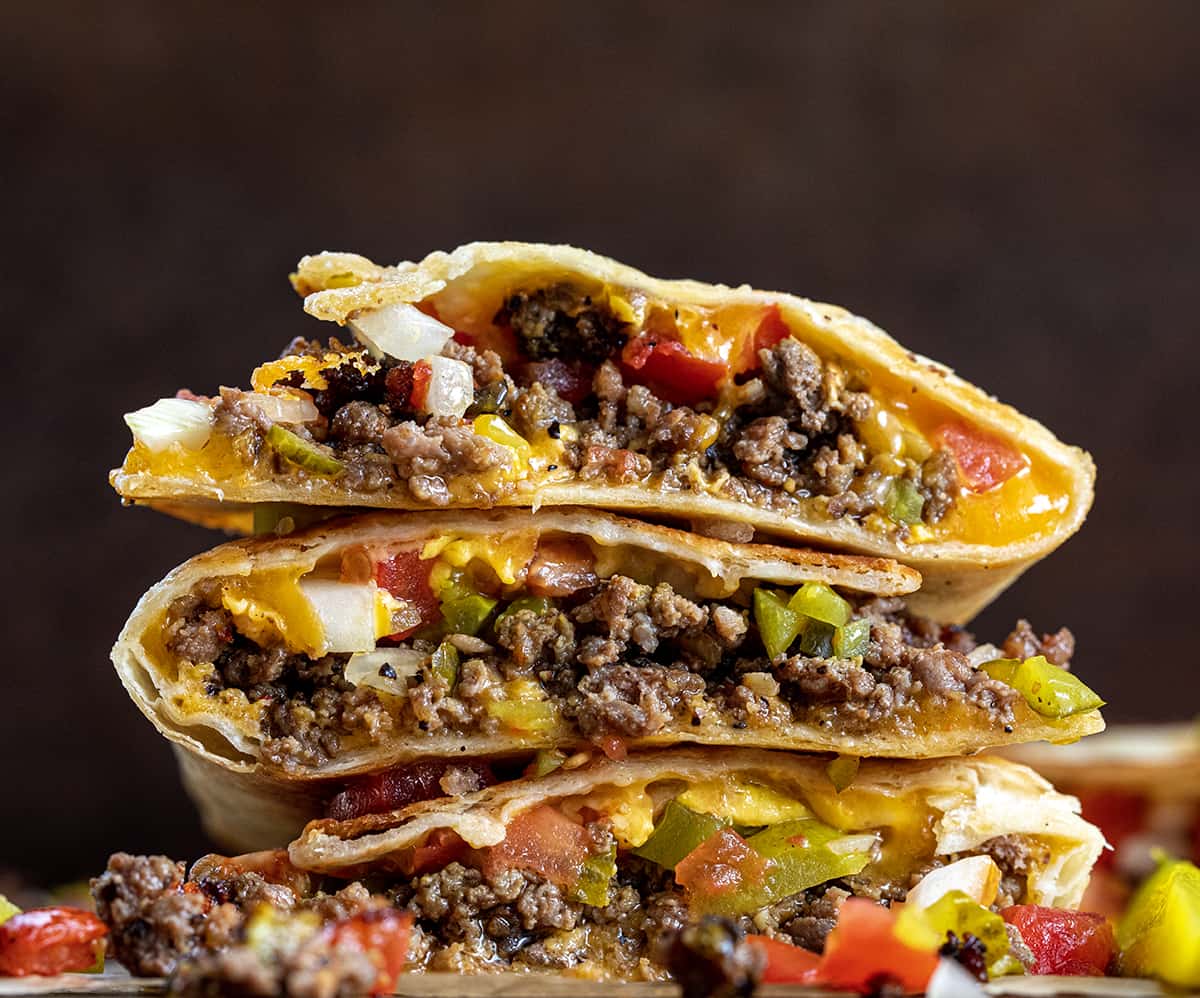 Stacked Cheeseburger Quesadillas on a Cutting Board with Cut End Facing Camera.
