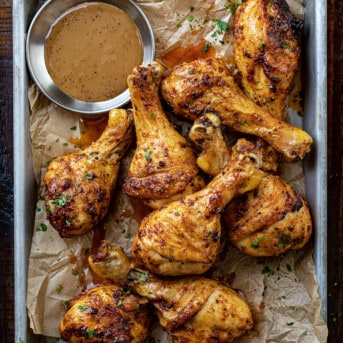 Chicken Legs on a Pan with Sauce on a Cutting Board.