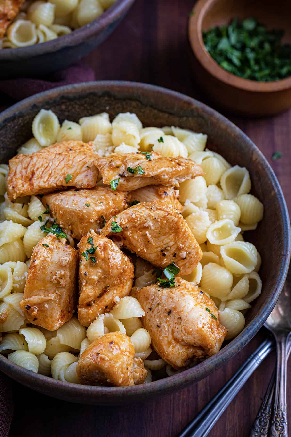 Bowl of Chicken and Buttered Noodles on a Cutting Board.