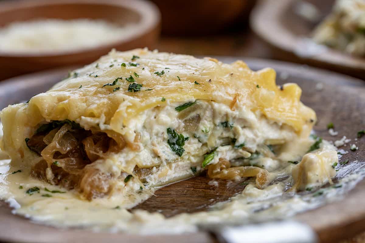 Piece of French Onion Lasagna Roll-Up on a Plate with a Bite Removed.