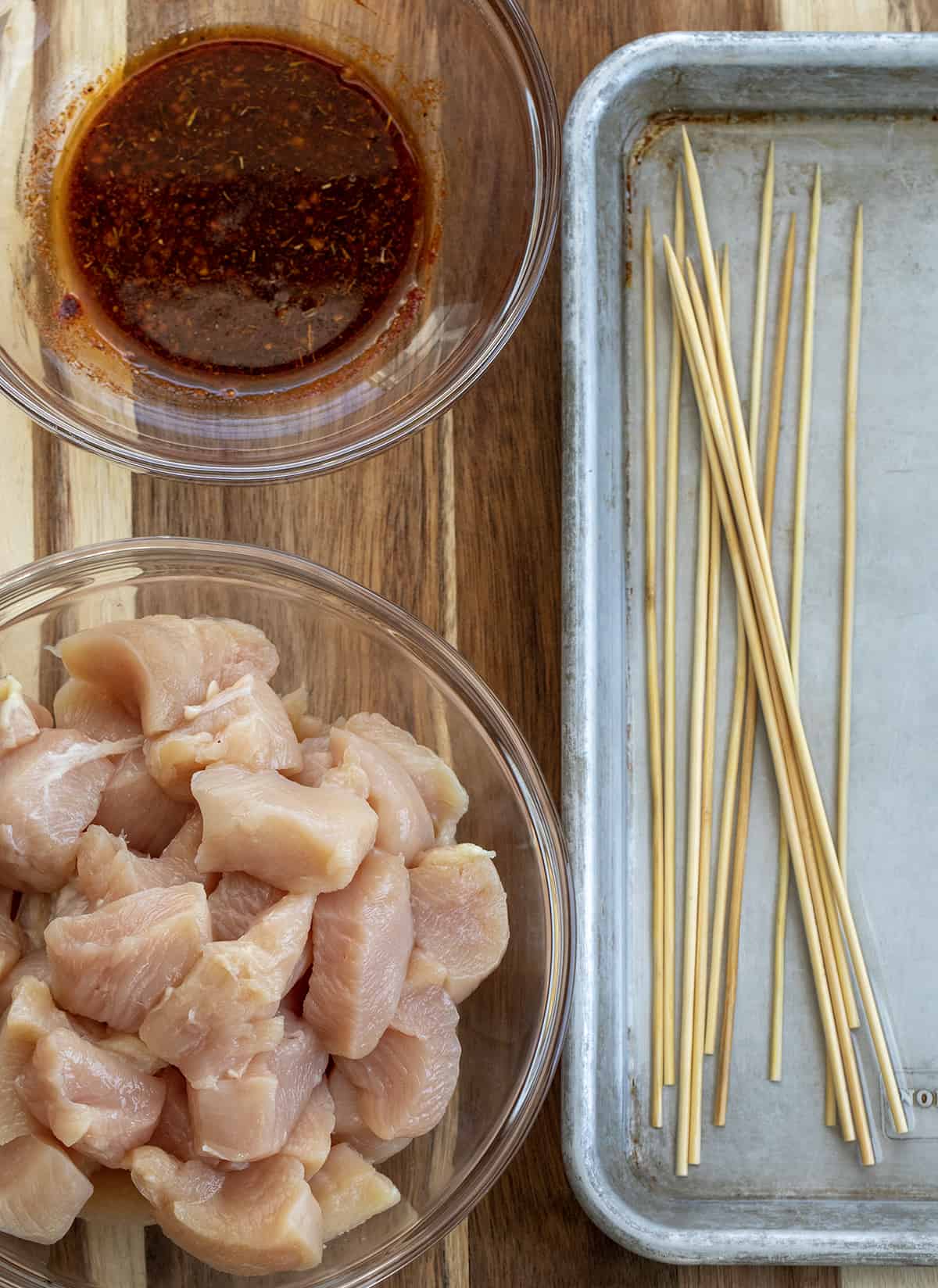 Chicken, Sauce, and Skewers Soaking in Water.