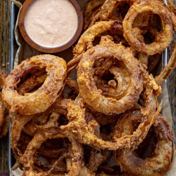Pan of Onion Rings with Fry Sauce on Crumpled Parchment Paper from Overhead.