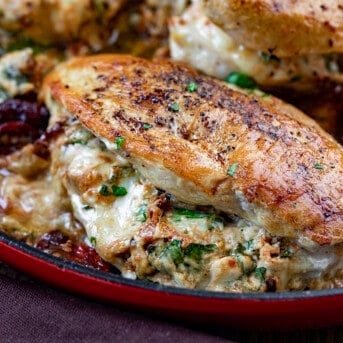 Close up of Stuffed Sun-Dried Tomato Chicken in Red Skillet.