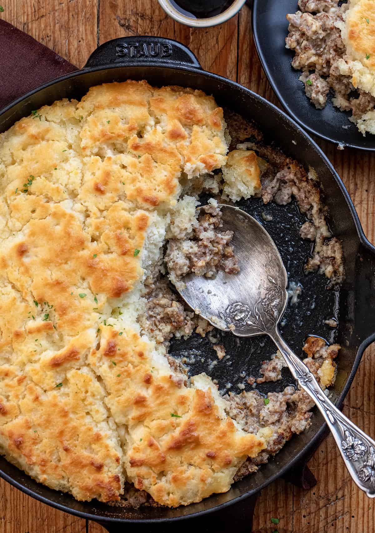 Skillet with Butter Swim Biscuits and Gravy Bake in it and Some Removed Showing the Creamy Gravy. 