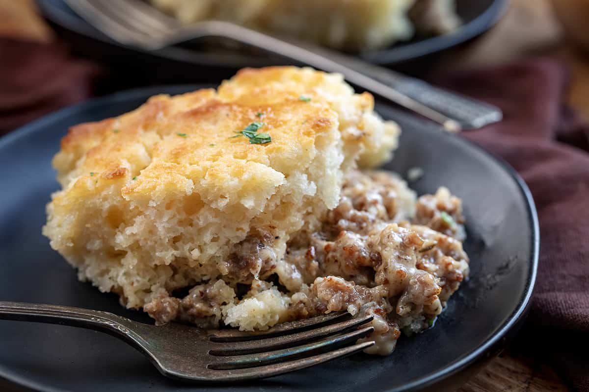 Plate with Mile High Butter Swim Biscuits and Gravy Bake with a Fork.