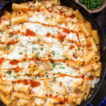 Skillet of Buffalo Chicken Pasta on a Dark Cutting Board.