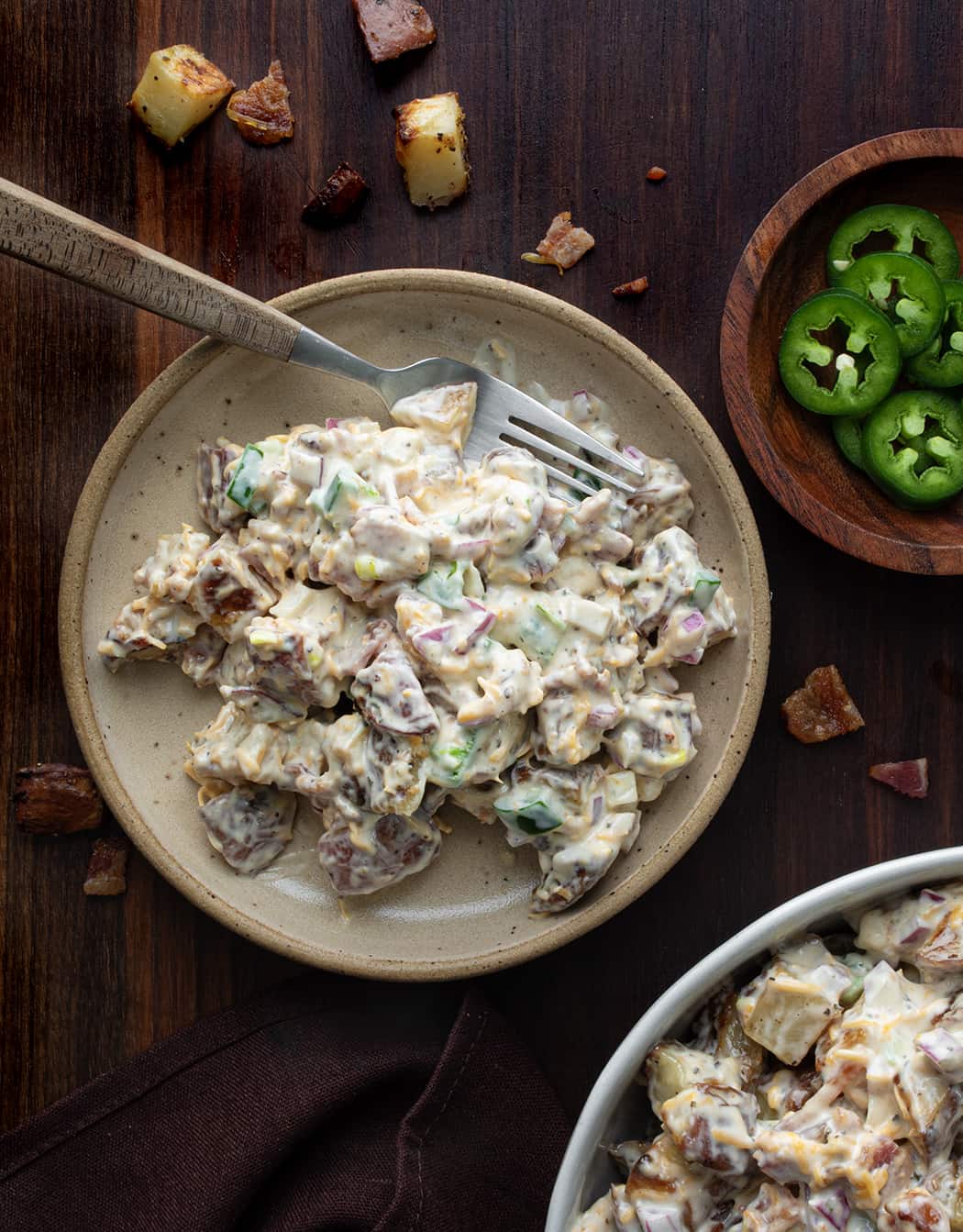 Plate of Jalapeño Popper Roasted Potato Salad Next to Bowl and Jalapenos off to the Side.