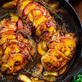 Roasted Peach Chicken in a Black Skillet with a Thyme Garnish.