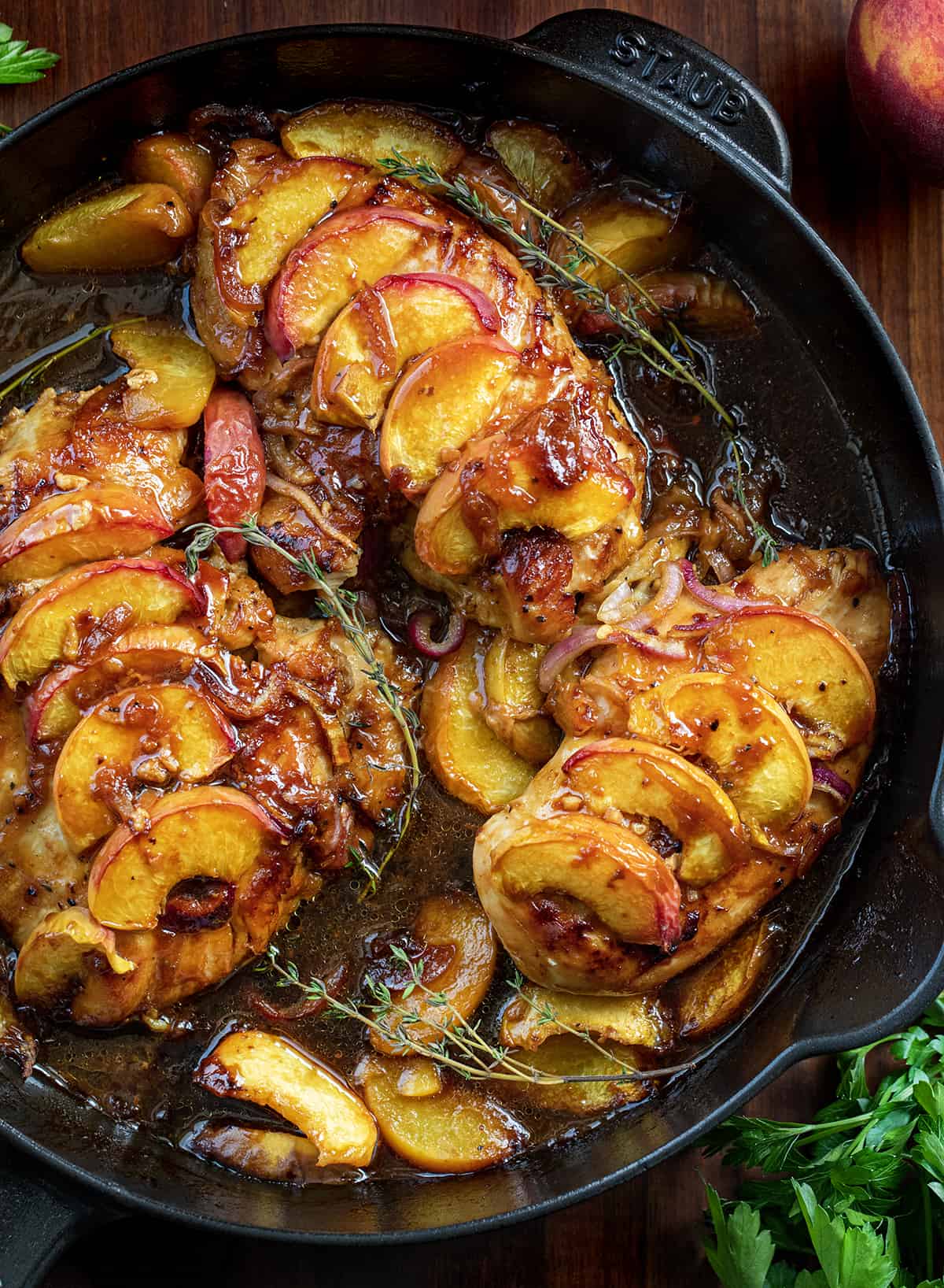 Roasted Peach Chicken in a Black Skillet with a Thyme Garnish. 