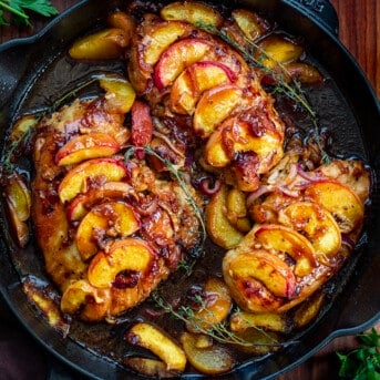 Roasted Peach Chicken in a Black Skillet with a Thyme Garnish.