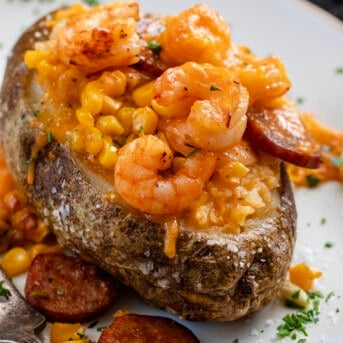 Close up of a Shrimp Boil Twice Baked Potato on a White Plate.