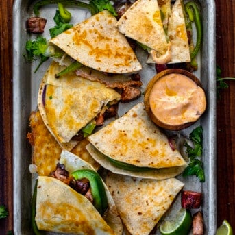Cut up Chipotle Steak Quesadilla in a Pan with Sauce.